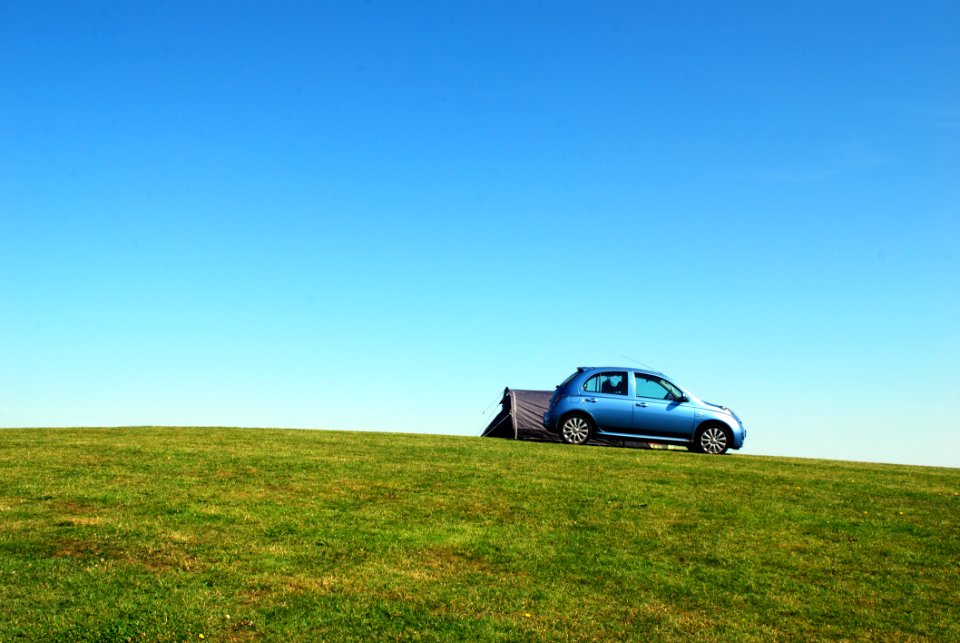 Blue Hatchback On Green Grass Field Under Blue Sky photo