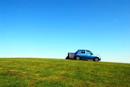 Blue Hatchback On Green Grass Field Under Blue Sky photo