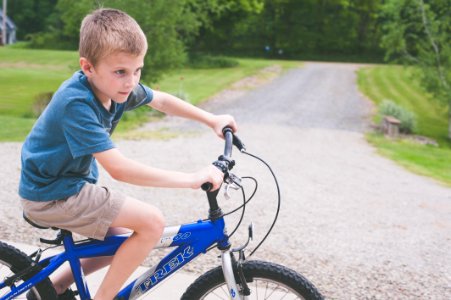 Boy Rides Blue Trek Bike At Daytime photo