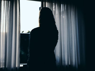 Silhouette Of Woman Standing Beside Window photo