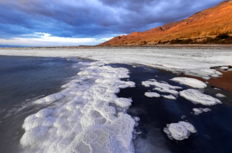 Body Of Water With Bubbles Near Mountain photo