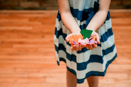 Girl Holding Orange And Green Cut Papers photo