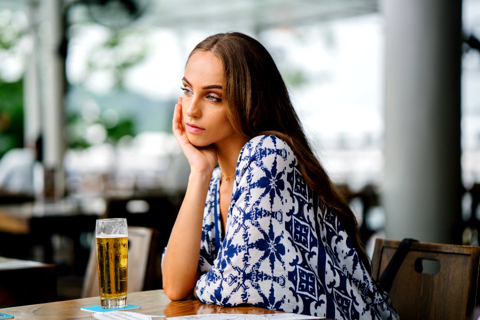 Woman In White And Blue Top Sitting In Front Table
