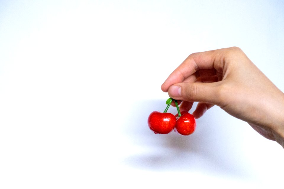 Person Holding Red Cherries
