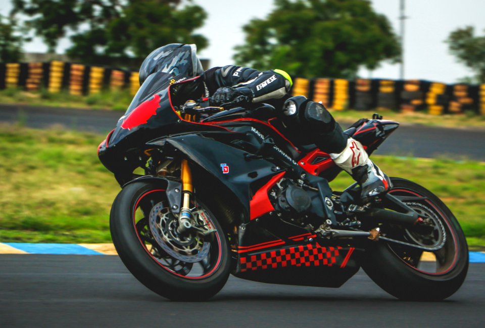 Man With Black Alpinestar Racing Suit Riding Black And Red Sports Bike