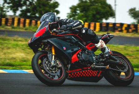Man With Black Alpinestar Racing Suit Riding Black And Red Sports Bike