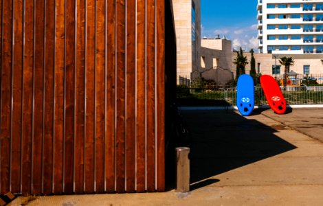 Red And Blue Surfboards Near Brown Wooden House