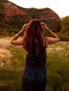 Woman Wearing Red And Blue Floral Dress Standing Beside Mountain