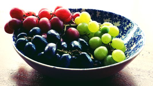 Red Black And Green Grapes In Round Blue And White Floral Ceramic Bowl