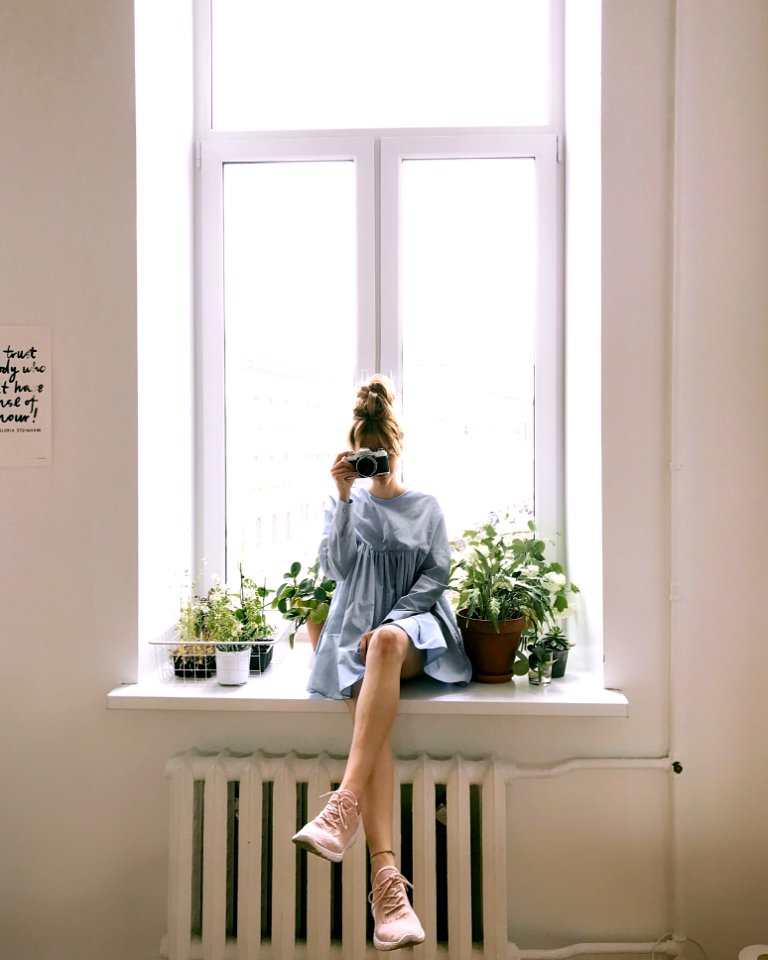 Woman In Grey Long-sleeved Dress Sitting On Window