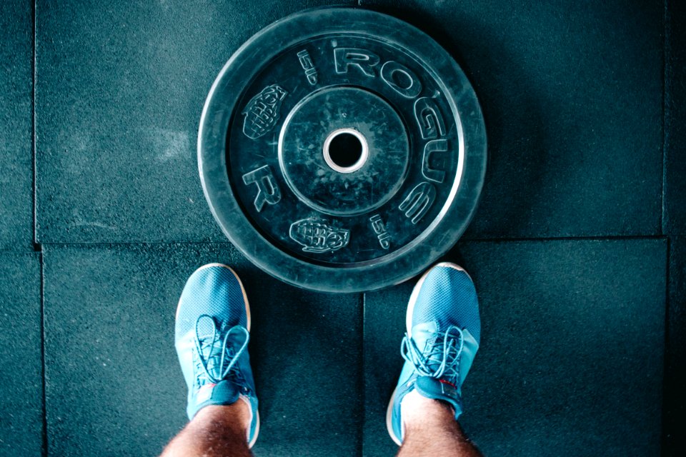Black Steel Gym Plate And Pair Of Blue Running Shoes