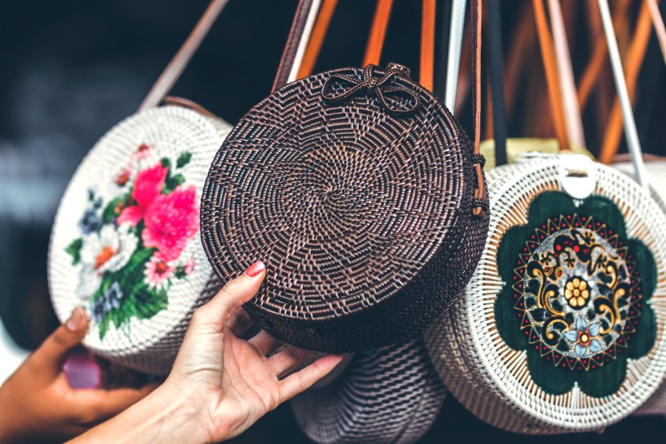 Person Holding Round Black Wicker Crossbody Bag