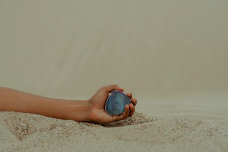 Person Holding Gemstone On Seashore