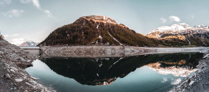 Green Covered Mountain Reflected On Calm Water Under Clear Sky Landscape Photo photo