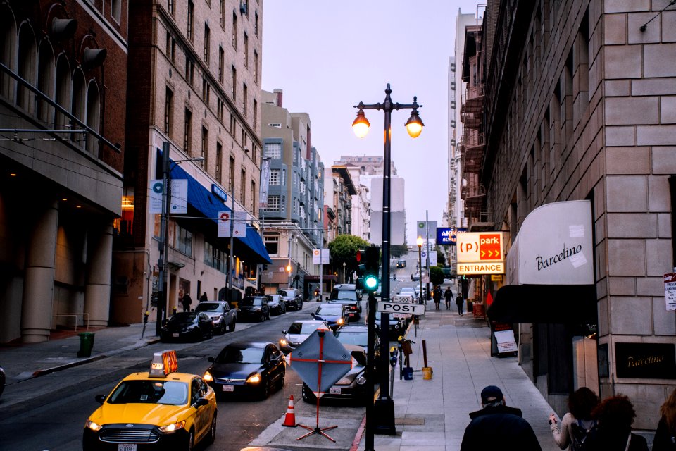 White Taxi On Road Between Buildings At Daytime photo