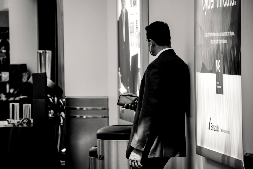 Man In Suit Jacket Near Poster