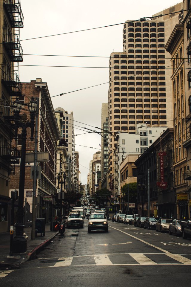 Cars On Street Surrounded By Buildings Under Dark Sky photo