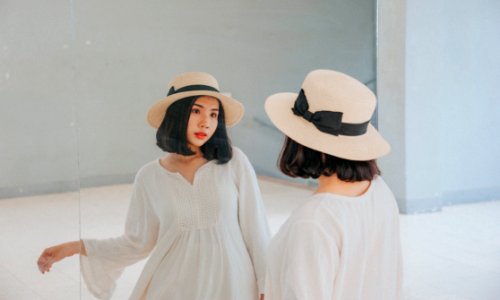 Woman Wearing White Long-sleeved Dress And Beige Sun Hat photo