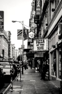 Grayscale Photography Of Pizza By The Slice Signage