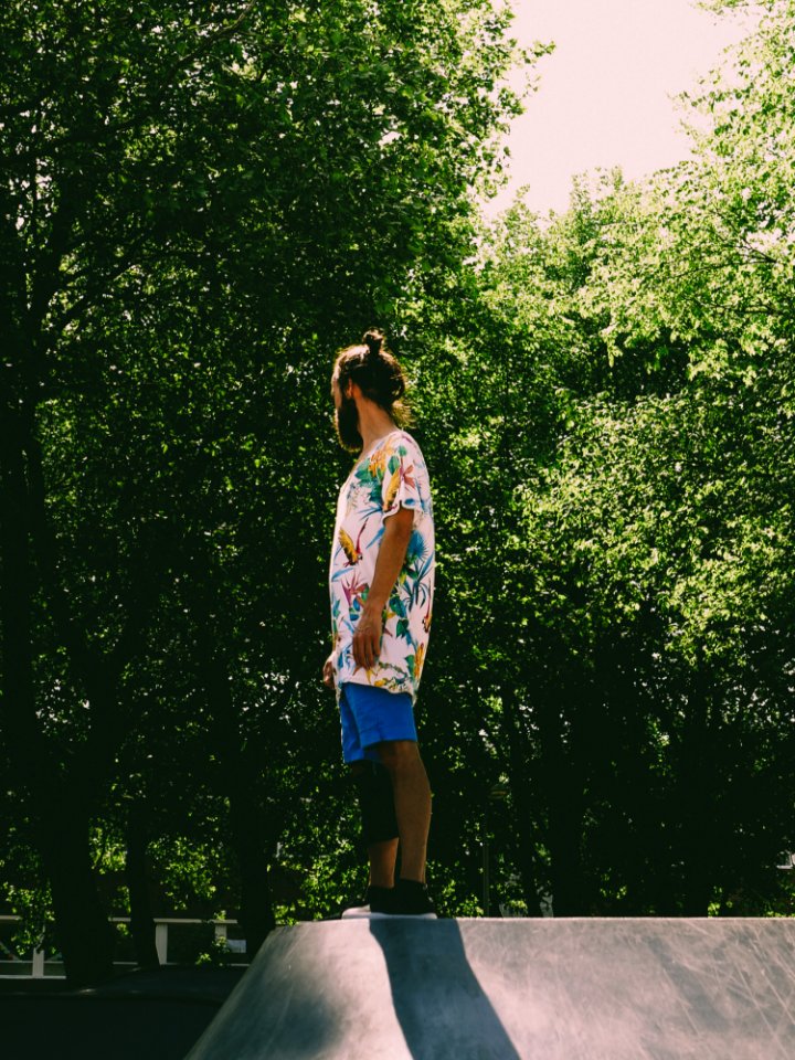 Man Wearing White And Multicolored Floral Standing Near Trees