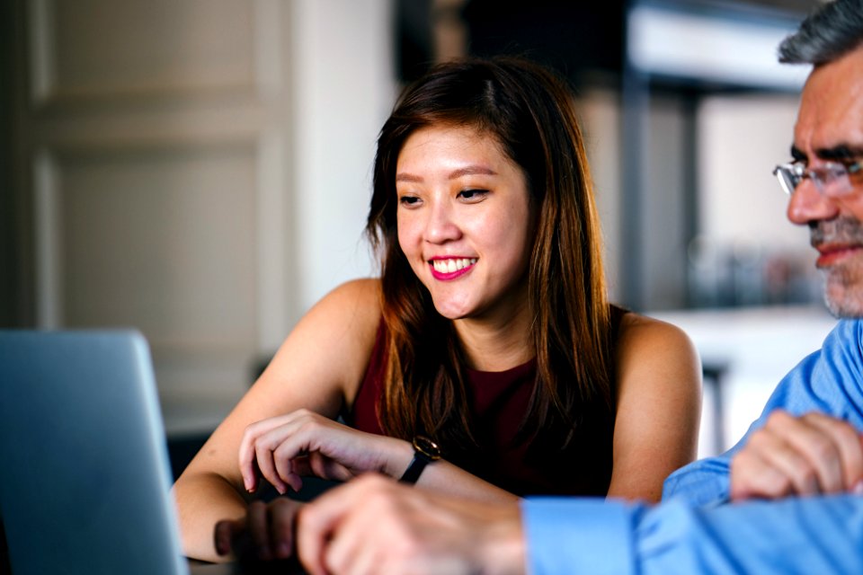 Woman And Man Looking At Laptop