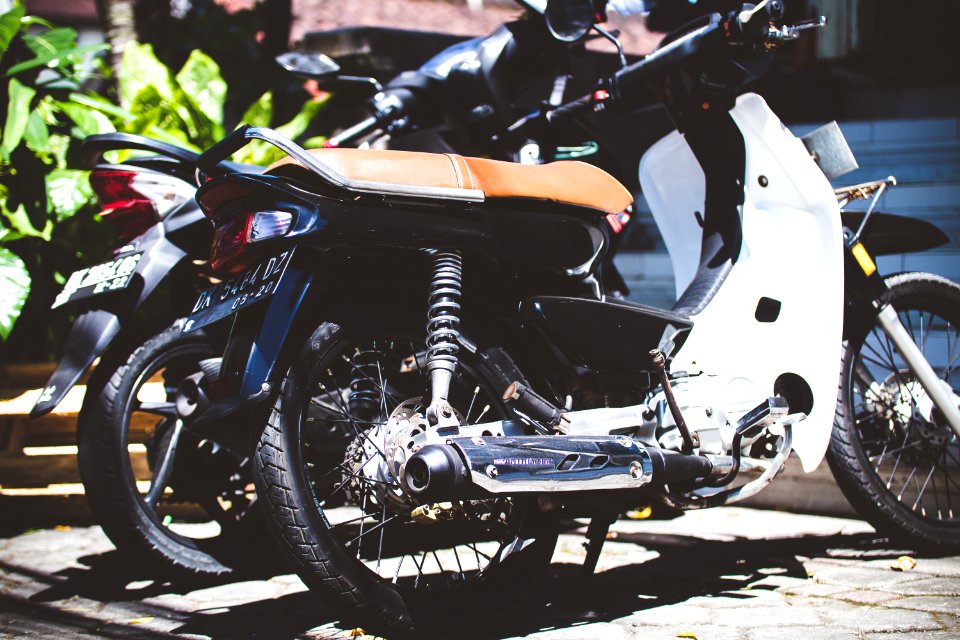 White Underbone Motorcycle Parked Beside A Motorcycle