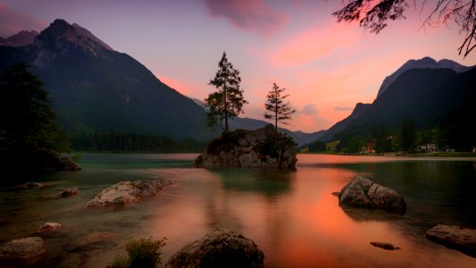 White Rock Formation On Water With Mountain Background