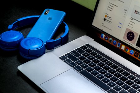 Macbook Pro Beside Blue Wireless Headphones photo