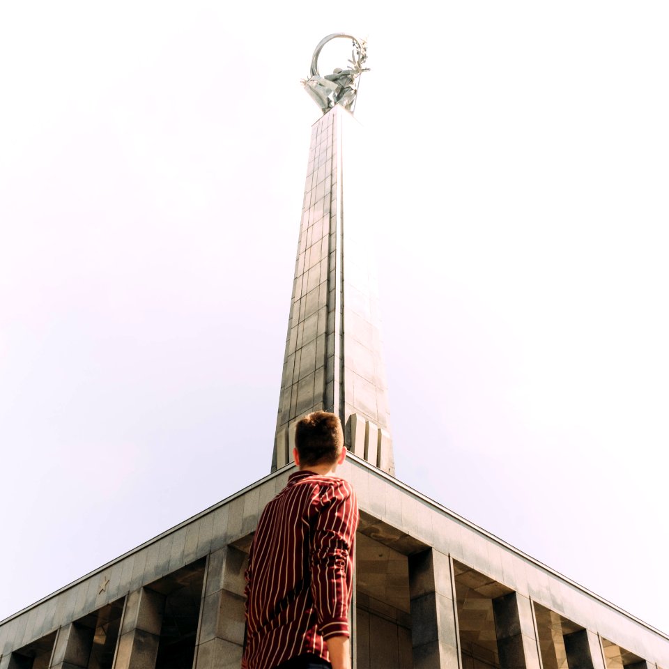 Man Standing In Front Of Gray Concrete Tower photo