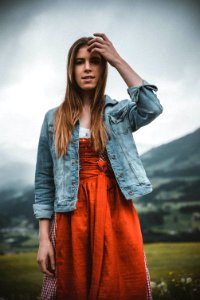 Woman In Blue Denim Button-up Jacket Behind Green Grass Field photo