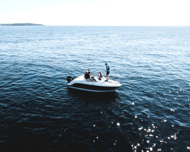 Three Person On White Motorboat At Daytime photo