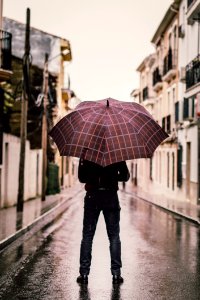 Person Wearing Black Pants Holding Umbrella Standing On Road photo