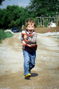 Boy Wearing Red Brown And White Stripe Sweater Running Photo photo