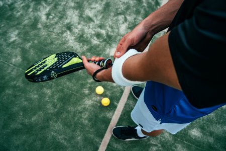 Person Holding Black And Green Tennis Racket