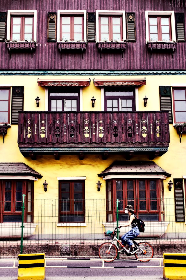 Woman Riding On Bicycle Near House photo