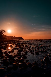 Photo Of Rock Rubles Beside Calm Body Of Water During Golden Hour photo