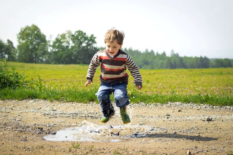 Boy Jumping Near Grass At Daytime