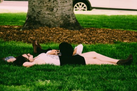 Woman Wearing White Tank Top Lying On Green Grass photo