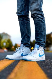 Person Wearing White And Blue Air Jordan 1s photo