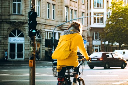 Woman Wearing Yellow Hooded Coat Riding Bicycle photo