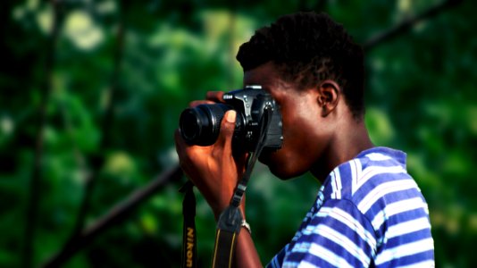 Man Wearing Blue And White Striped Shirt Using Nikon Camera photo