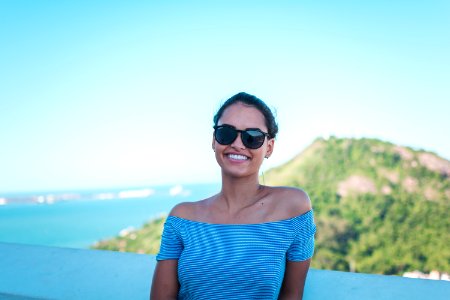 Smiling Woman Wearing Grey Striped Off-shoulder Top And Black Sunglasses photo