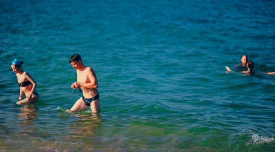 People Swimming On Body Of Water photo