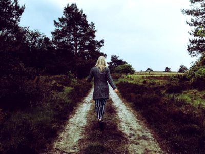 Woman In Grey Cardigan With Grey And Black Striped Pants Walking At The Pathway