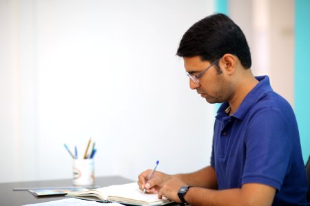Man In Blue Polo Shirt Writing photo