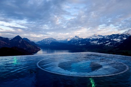 River Surrounded By Mountains Under White Clouds