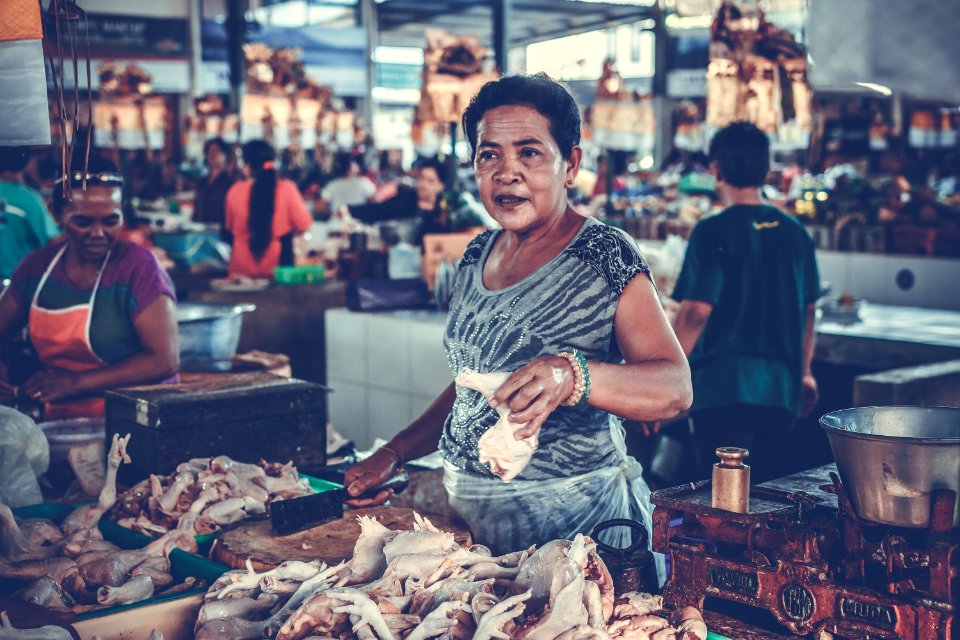 Woman In Gray Shirt Holding A Chicken Piece