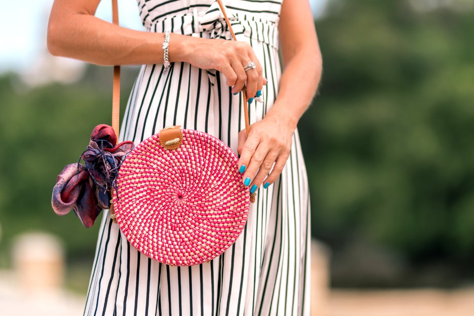 Woman Wearing White And Black Striped Dress Holding Her Red Sling Bag