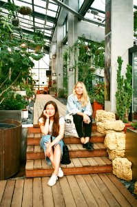 Photography Of Women Sitting On Wooden Stairs