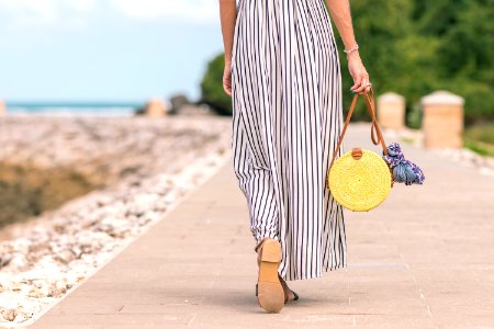 Woman Wearing Black And White Striped Maxi Skirt Holding Brown Bag photo